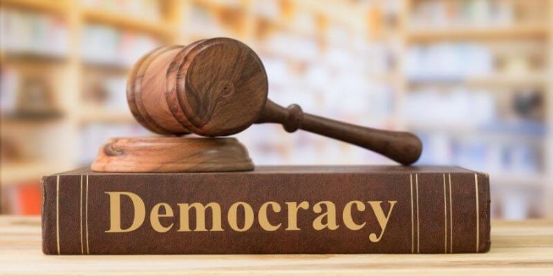 a gavel on a book titled Democracy