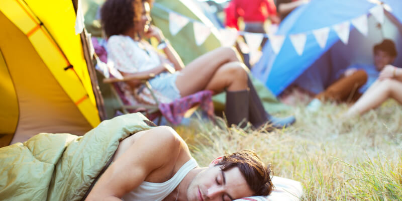 people sleeping or sitting in a  group of tents