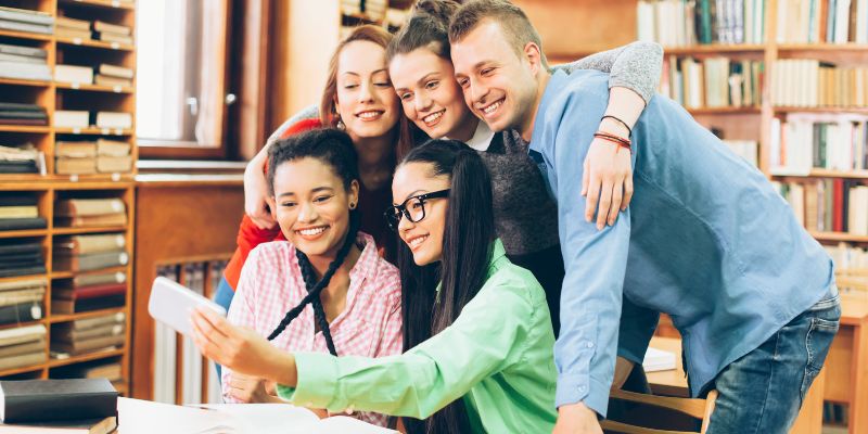 students taking a group selfie in the library