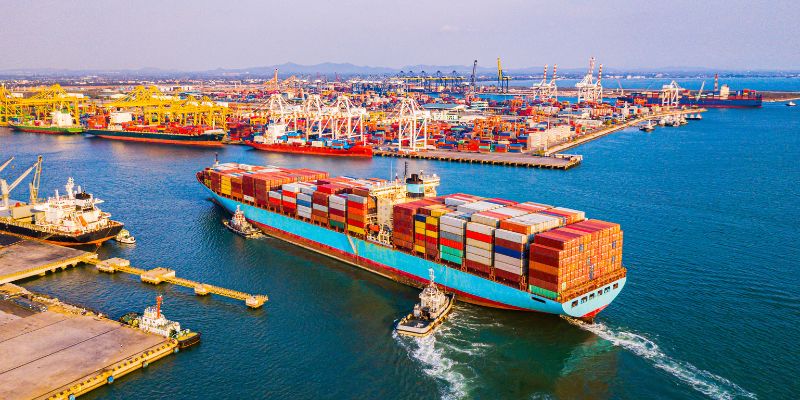 A body of water containing filled with cargo vessels.