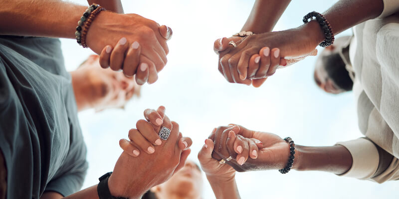 people in a circle holding hands. 